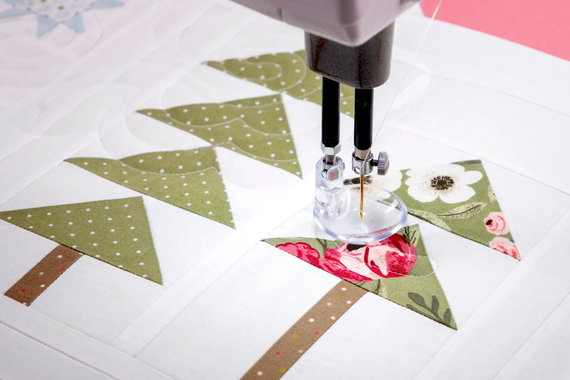 Longarm machine quilting a white quilt with tree paper pieced quilt block